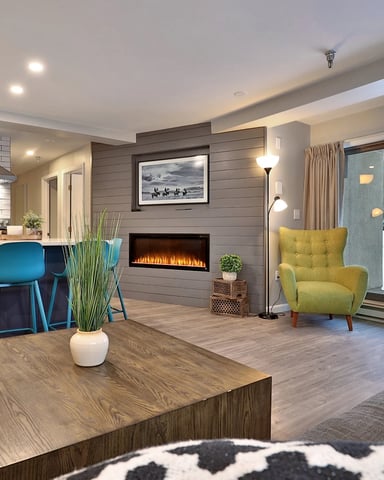 Cozy living room with neutral tones and a Killington ski resort poster on the wall.