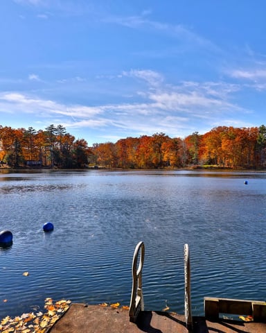 Wide-angle view of Lake Bomoseen in Vermont, with a boat and clear sky.