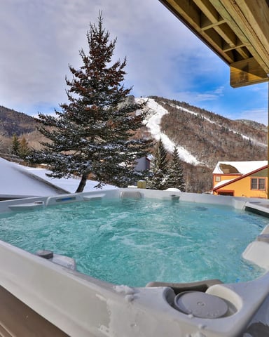 Hot tub on the deck of a rental cabin in Killington winter.